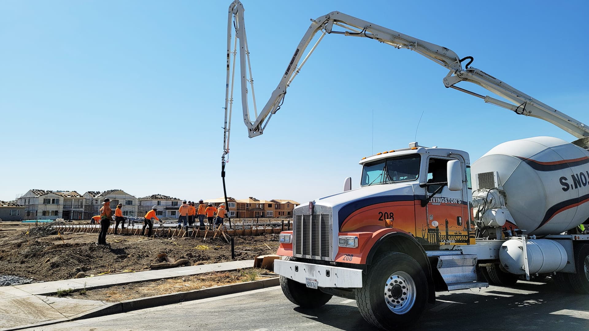 Livingston's mixer truck feeding a boom pump as crews pour foundations in a new subdivision