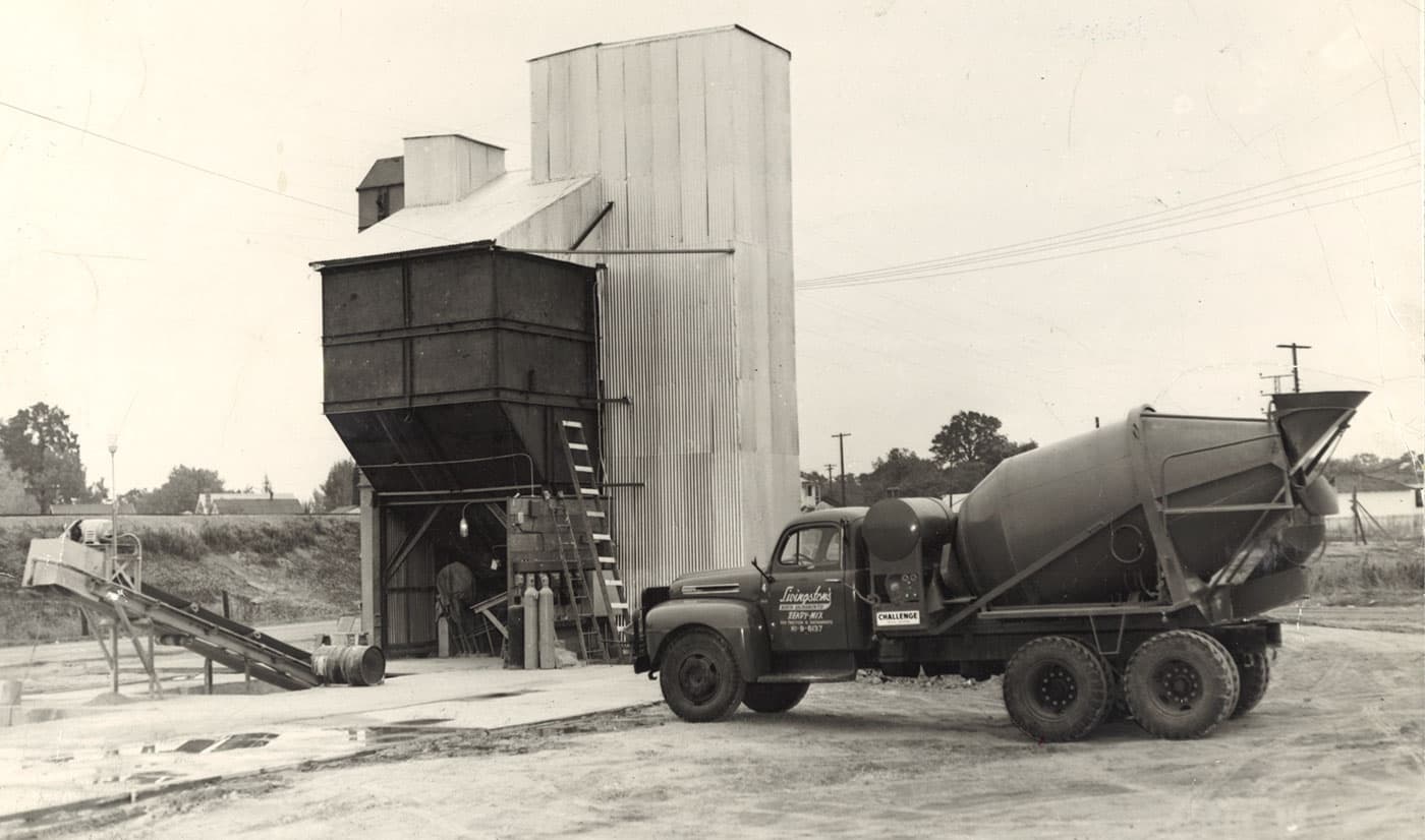 Early Livingston's ready-mix truck beside a corrugated-steel batch plant