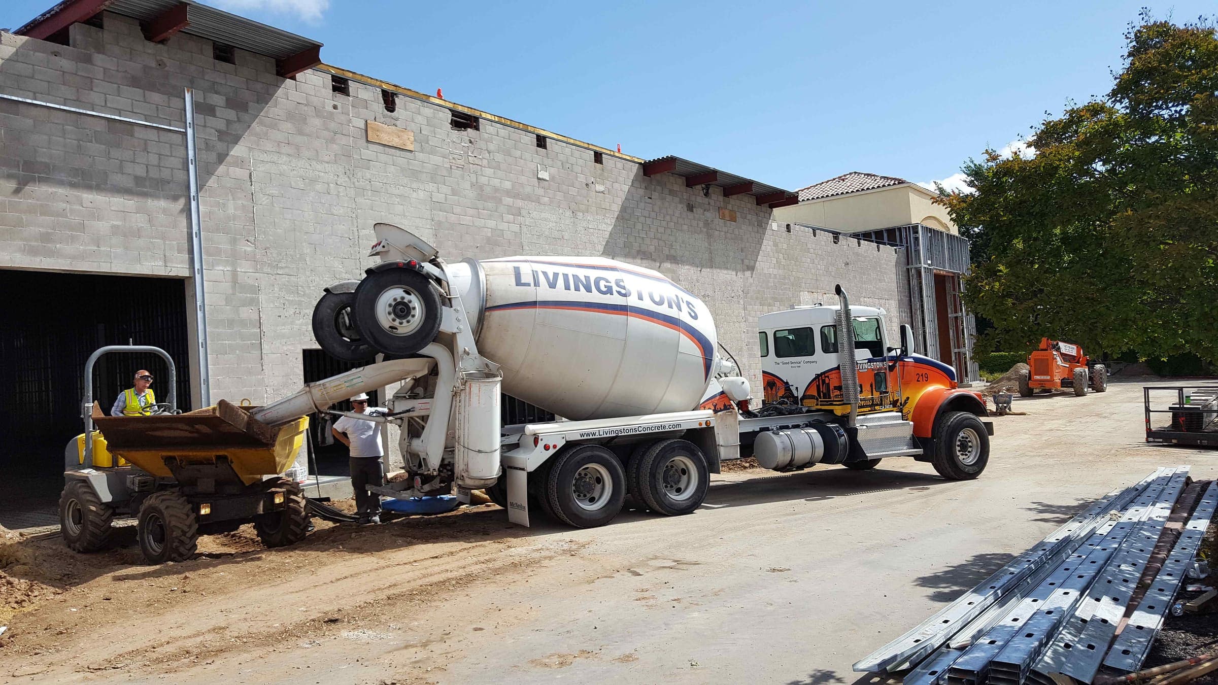 Livingston's mixer truck discharging ready-mix concrete into a site dumper at a commercial block building