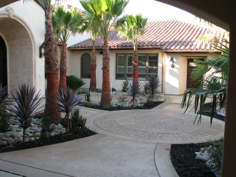 Residential courtyard with circular stamped concrete medallion and colored walkways